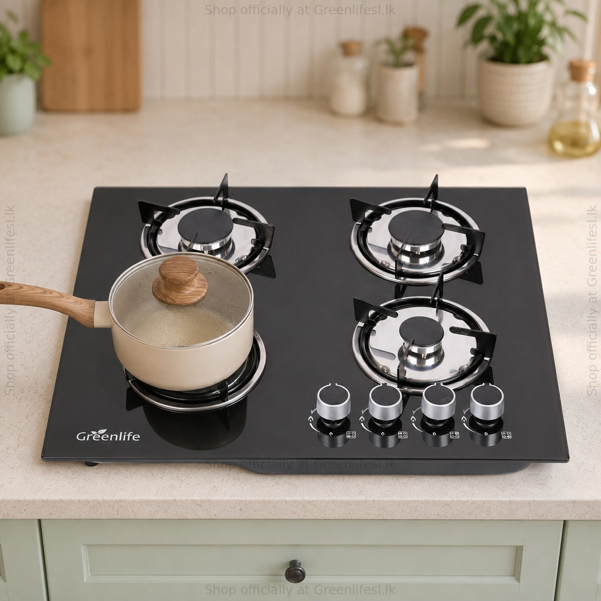 Green Life 4-burner tempered glass gas hob cooking with a saucepan in a home kitchen