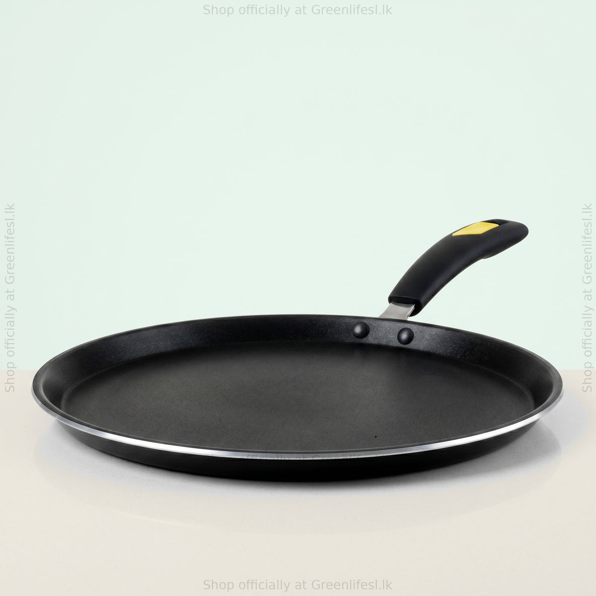 GreenChef Evok non-stick flat tawa from a low side angle showing the rim and riveted handle
