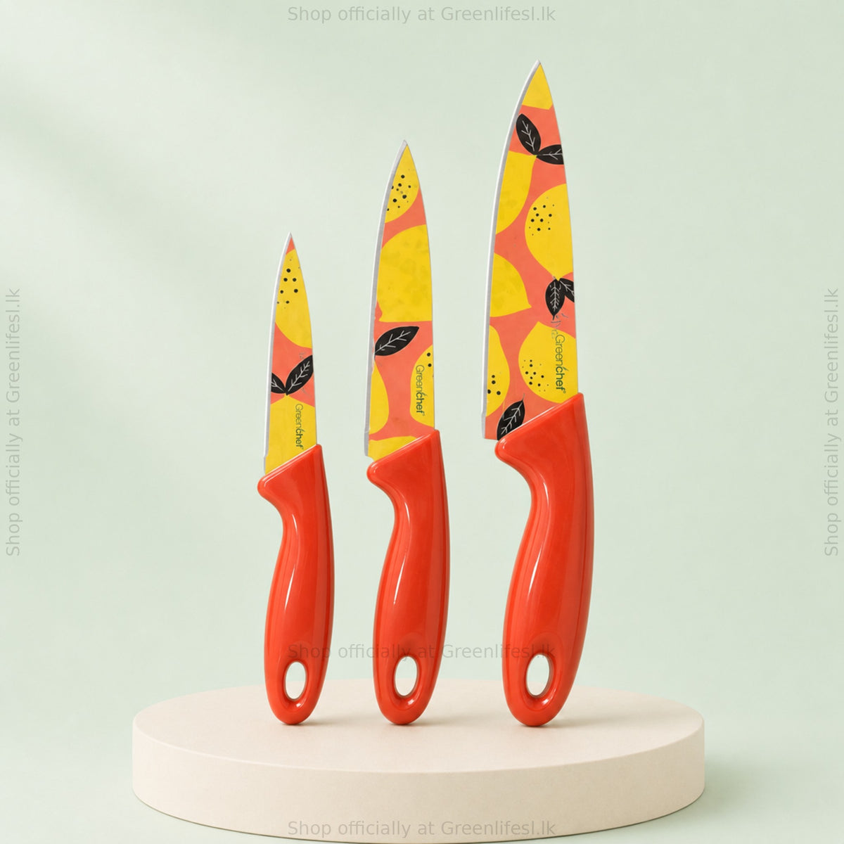 GreenChef Flora Trio 3-piece knife set with lemon-print blades and red handles, standing on a plinth