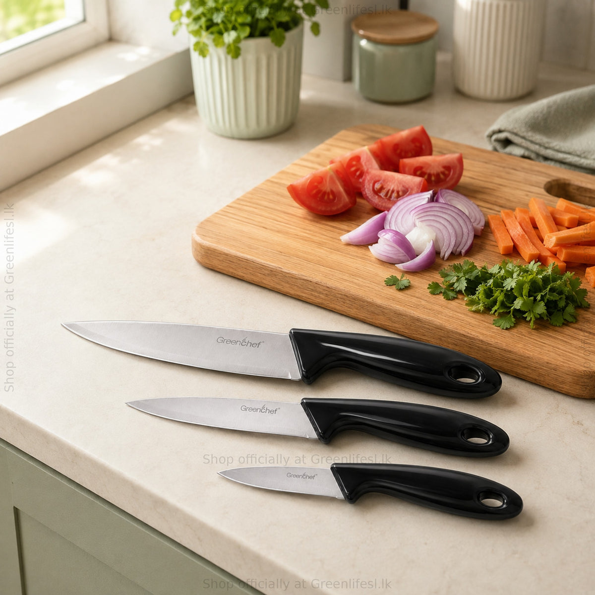 GreenChef 3-piece kitchen knife set, black, on a kitchen counter beside chopped vegetables