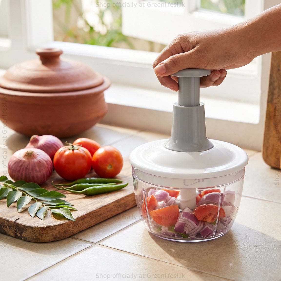 Greenlife 1.5L manual food chopper chopping onions and tomatoes on a kitchen counter