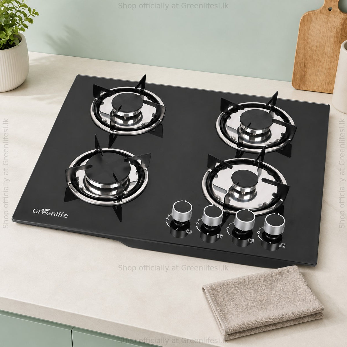 Green Life 4-burner tempered glass gas hob on a kitchen counter with a folded cloth