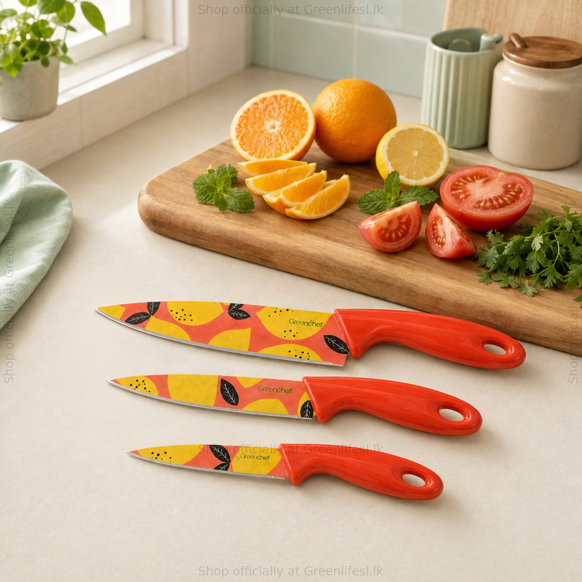 GreenChef Flora Trio 3-piece knife set on a kitchen counter beside citrus, tomatoes and herbs